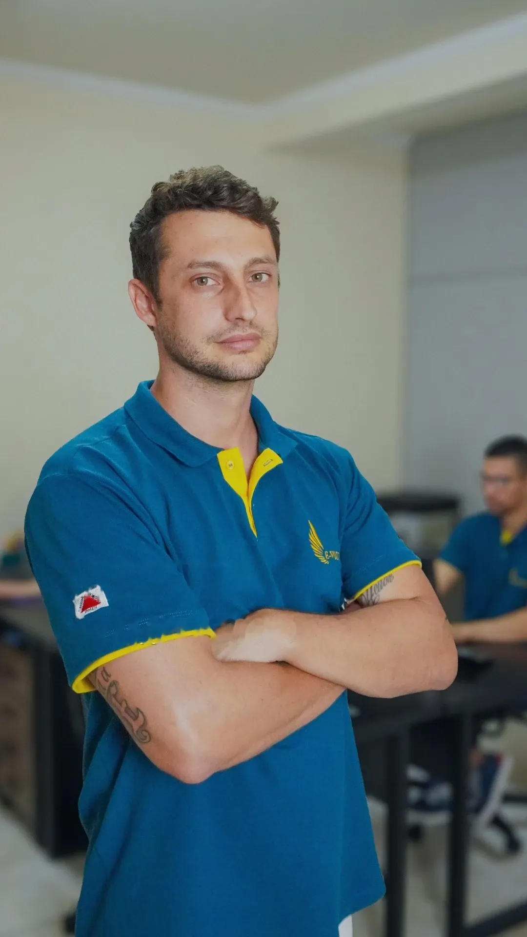Integrante da equipe da E-volução de uniforme, no escritório